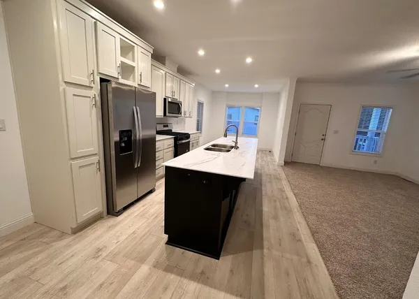 a kitchen with stainless steel appliances kitchen island granite countertop a refrigerator stove and oven