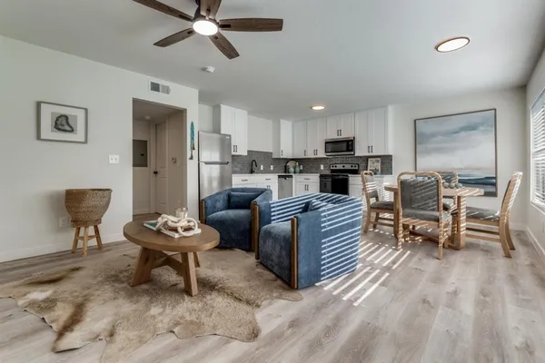 a living room with furniture and kitchen view