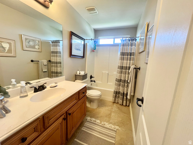 369 Culross Circle Tooele, UT 84074 - Photo 31 of 54 Bathroom featuring a warm wood vanity with an integrated sink, broad wall mirror, and a full bathtub with a shower