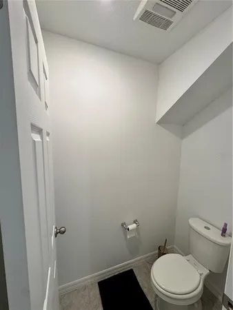 a white toilet sitting next to a shower