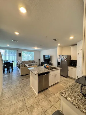 a kitchen with stainless steel appliances kitchen island granite countertop a sink and cabinets