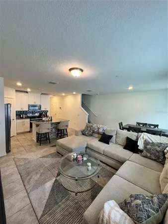 a living room with furniture and kitchen view