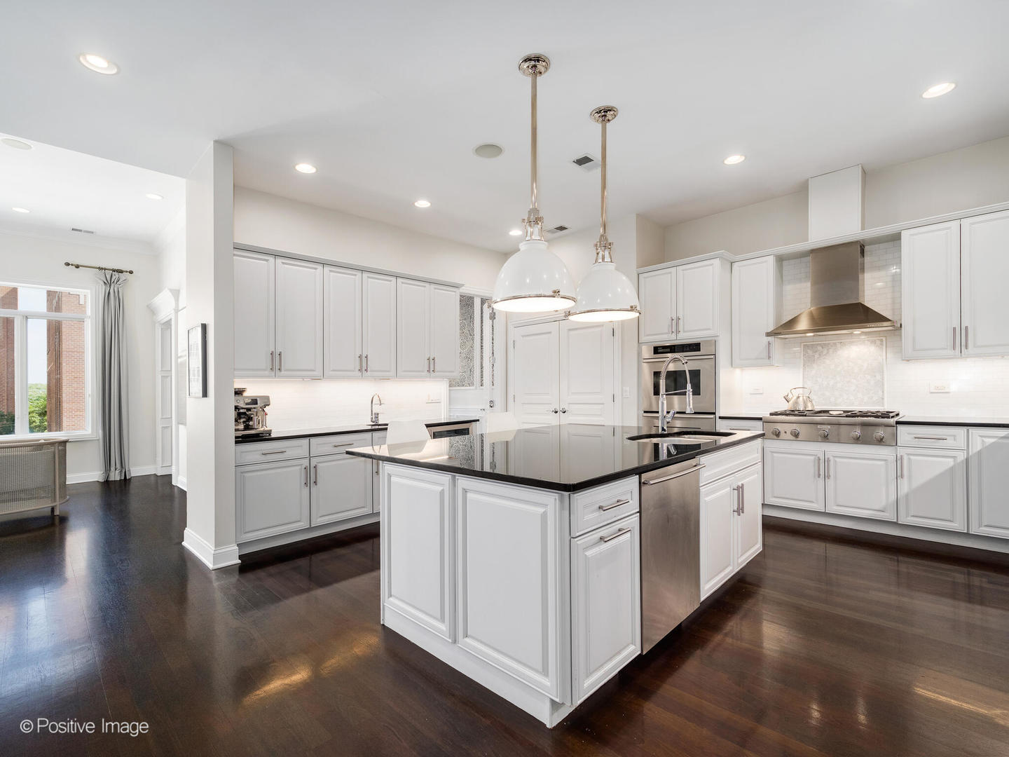 1359 West Fullerton Avenue, Unit PH Chicago, IL 60614 - Photo 14 of 33 a kitchen with stainless steel appliances kitchen island granite countertop a sink a stove and cabinets
