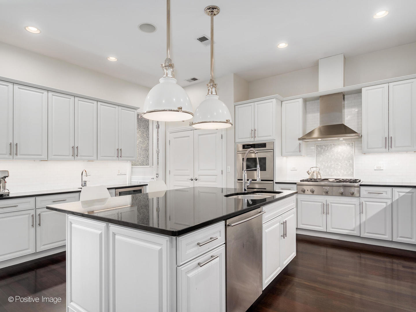 1359 West Fullerton Avenue, Unit PH Chicago, IL 60614 - Photo 15 of 33 a kitchen with kitchen island granite countertop a sink stove and white cabinets with wooden floor