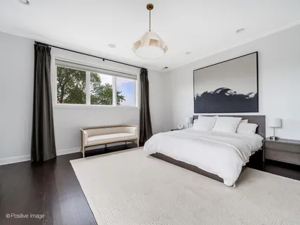 a bedroom with a bed and a painting on the wall