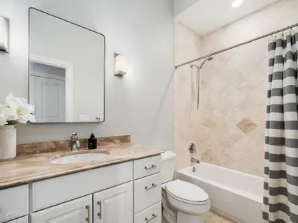 a bathroom with a granite countertop sink toilet a shower and a mirror
