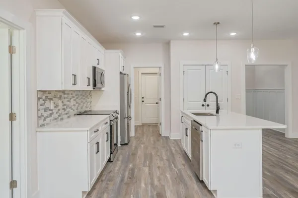 a kitchen with white cabinets appliances and sink