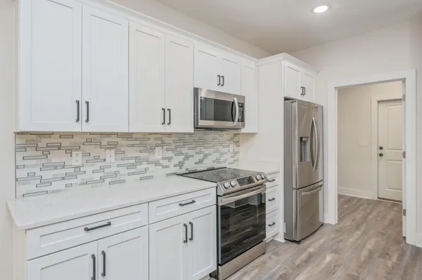 a kitchen with stainless steel appliances a stove microwave and refrigerator