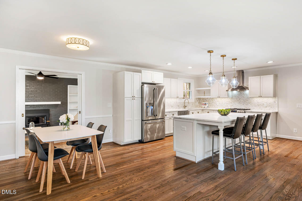 231 Flemington Road Chapel Hill, NC 27517 - Photo 3 of 43 a kitchen with a dining table chairs refrigerator and cabinets