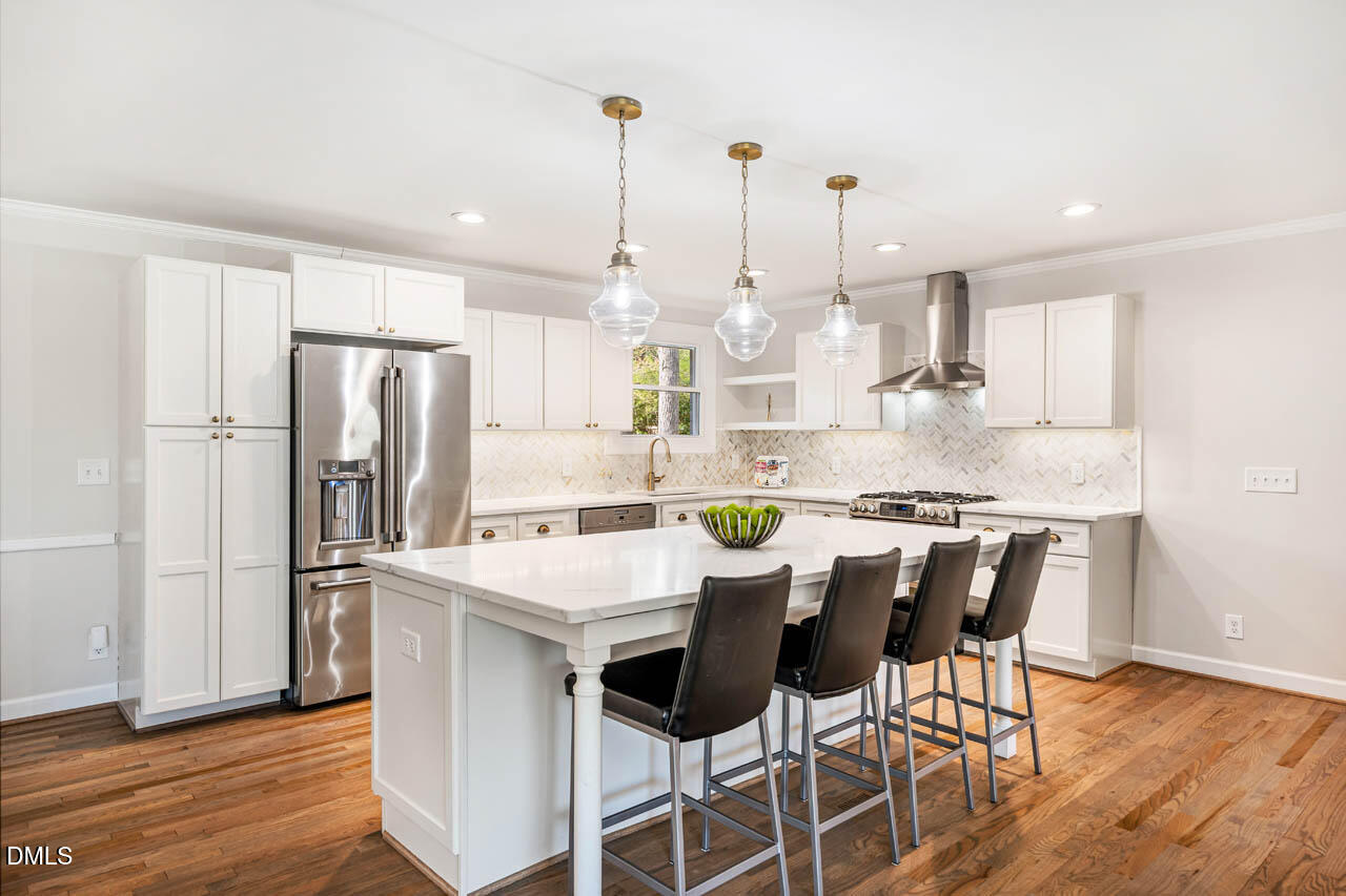 231 Flemington Road Chapel Hill, NC 27517 - Photo 4 of 43 a kitchen with stainless steel appliances kitchen island granite countertop a table chairs stove and refrigerator
