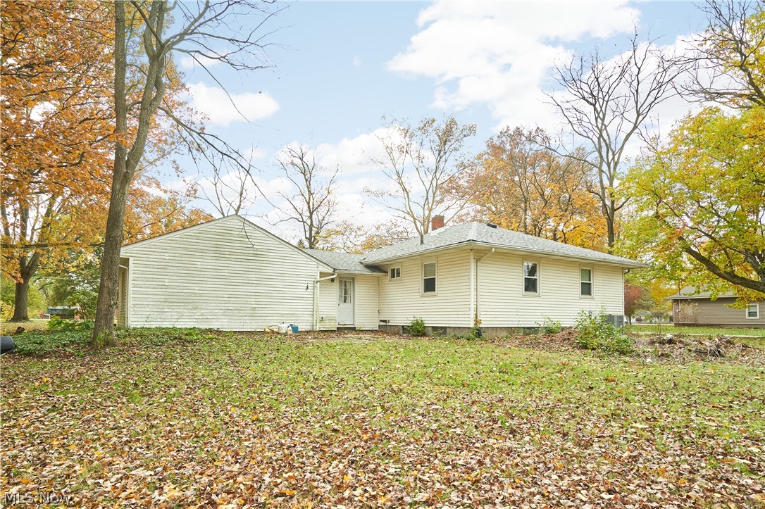 2941 Sweitzer Road Uniontown, OH 44685 - Photo 14 of 16 Rear view of house featuring a chimney and a lawn