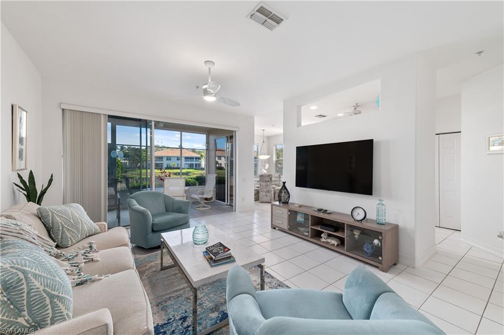 Living room featuring light tile patterned floors and ceiling fan