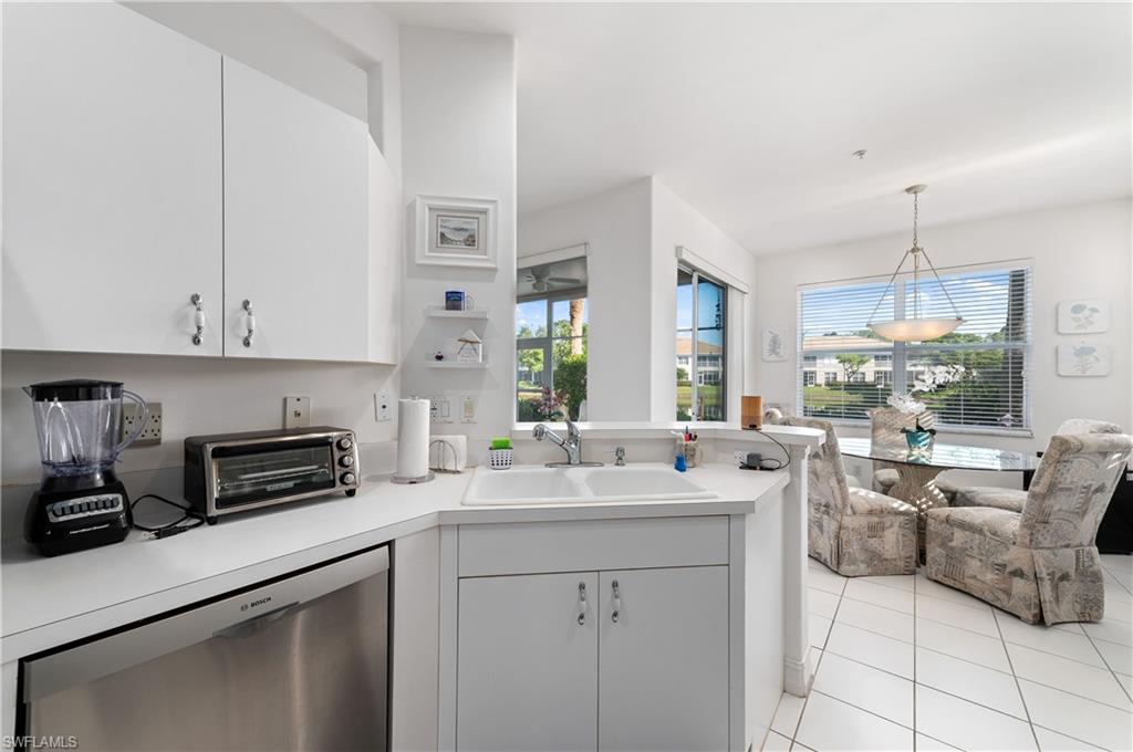 800 Carrick Bend Circle, Unit 103 Naples, FL 34110 - Photo 16 of 30 Kitchen featuring dishwasher, light countertops, light tile patterned flooring, white cabinetry, and a peninsula