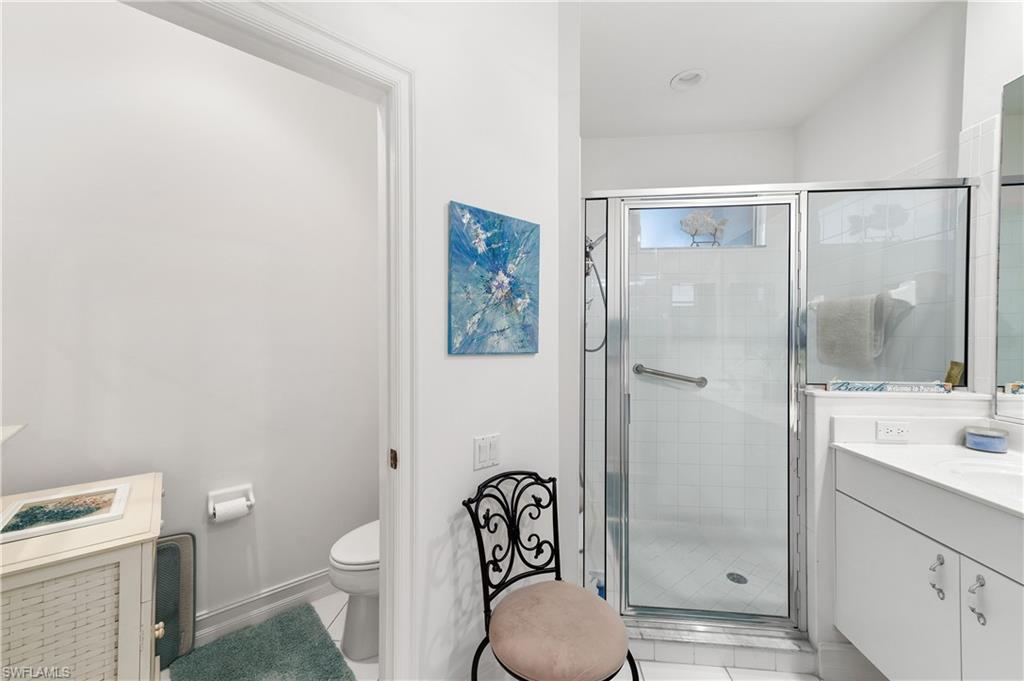 800 Carrick Bend Circle, Unit 103 Naples, FL 34110 - Photo 18 of 30 Full bath with vanity, a stall shower, and light tile patterned flooring