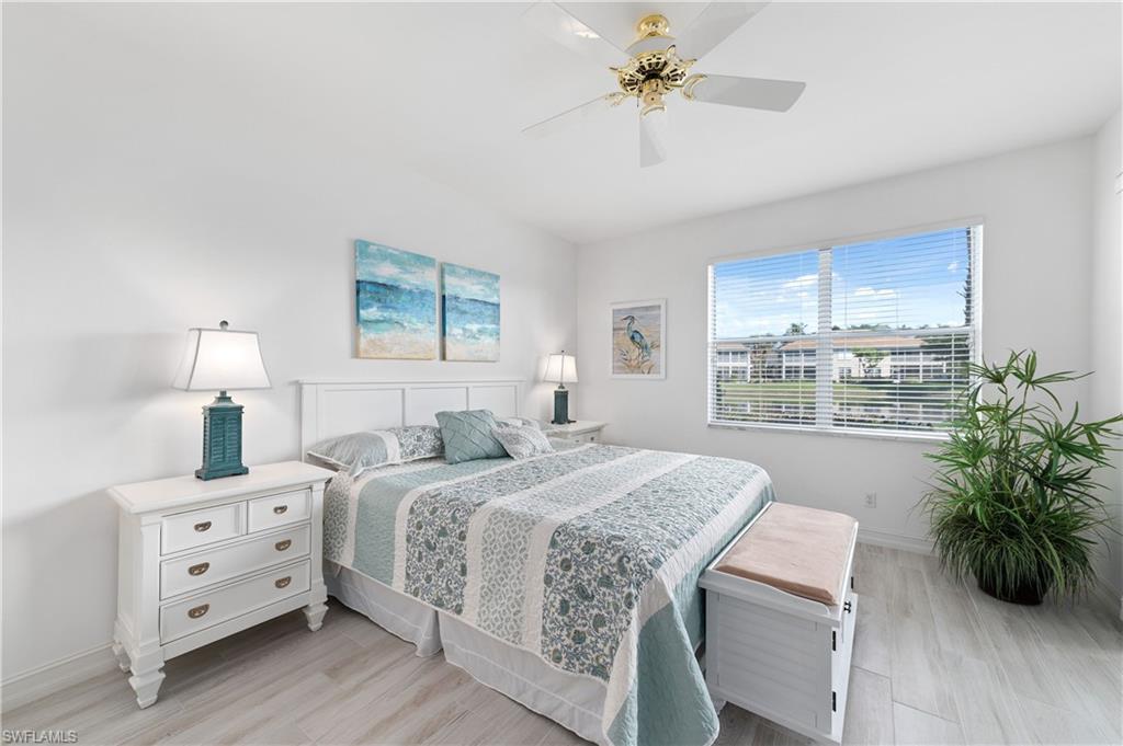 800 Carrick Bend Circle, Unit 103 Naples, FL 34110 - Photo 19 of 30 Bedroom with light wood finished floors and ceiling fan