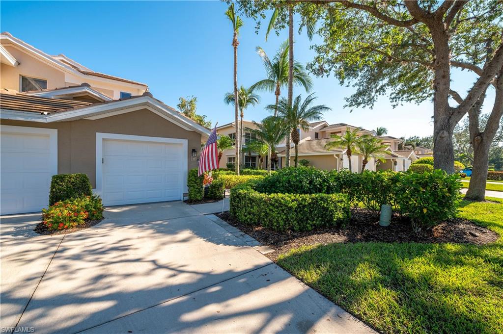800 Carrick Bend Circle, Unit 103 Naples, FL 34110 - Photo 2 of 30 View of front of property with stucco siding, a garage, and concrete driveway