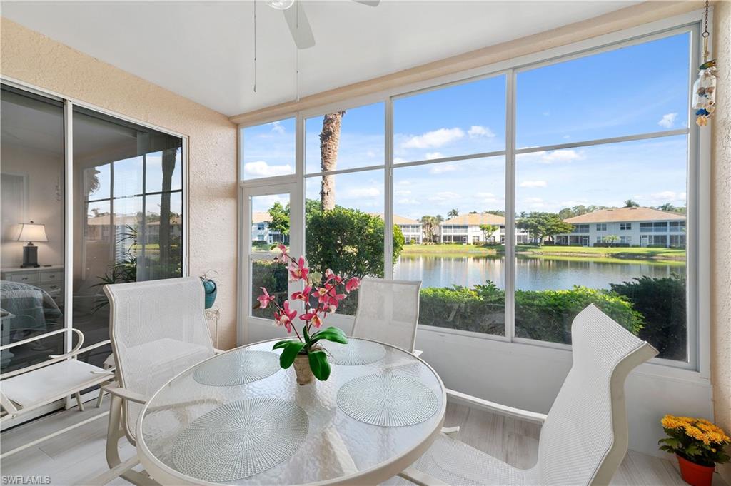 800 Carrick Bend Circle, Unit 103 Naples, FL 34110 - Photo 21 of 30 Sunroom / solarium with a textured wall, a water view, and wood finished floors