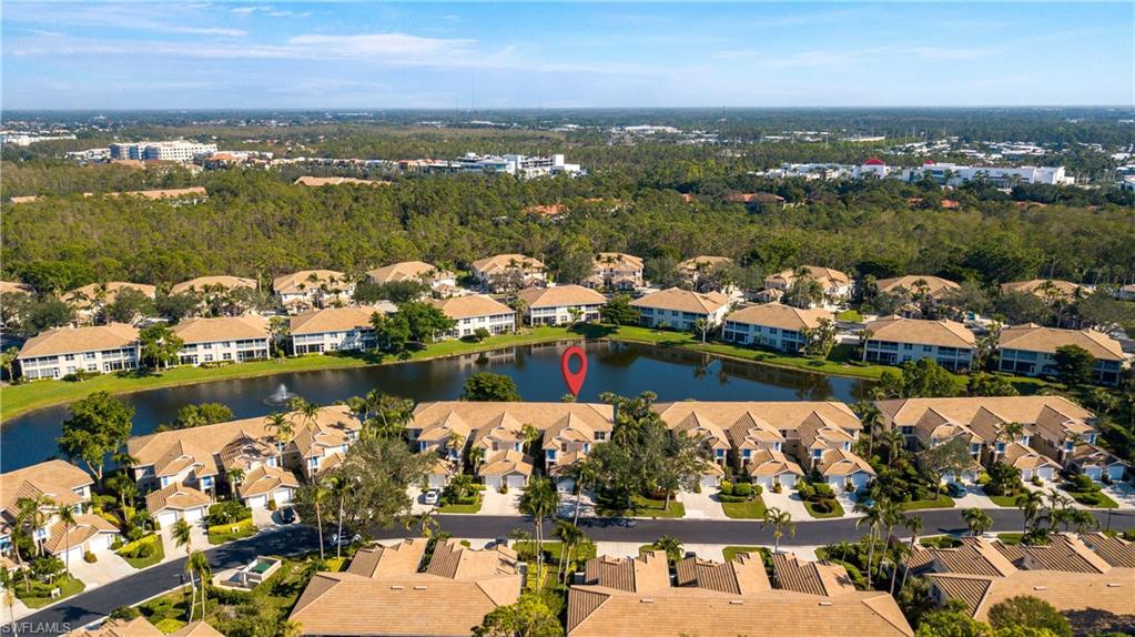 800 Carrick Bend Circle, Unit 103 Naples, FL 34110 - Photo 29 of 30 Drone / aerial view of a large body of water and a tree filled landscape