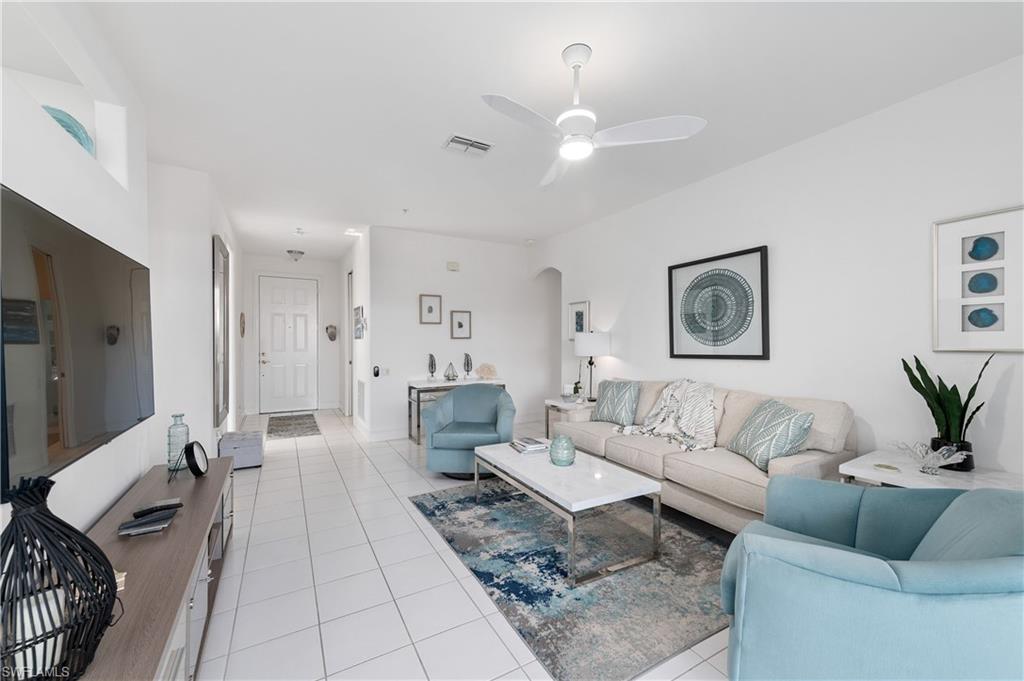 800 Carrick Bend Circle, Unit 103 Naples, FL 34110 - Photo 5 of 30 Living area with light tile patterned floors, arched walkways, and ceiling fan
