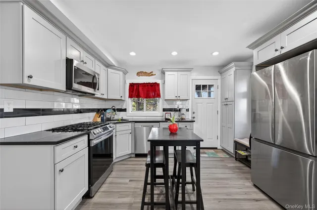 a kitchen with refrigerator and wooden floor