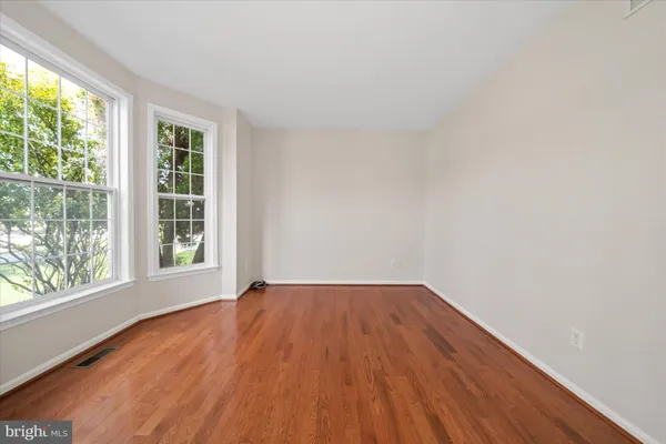 a view of a hallway with wooden floor and windows