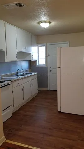 a kitchen with a sink a stove and cabinets