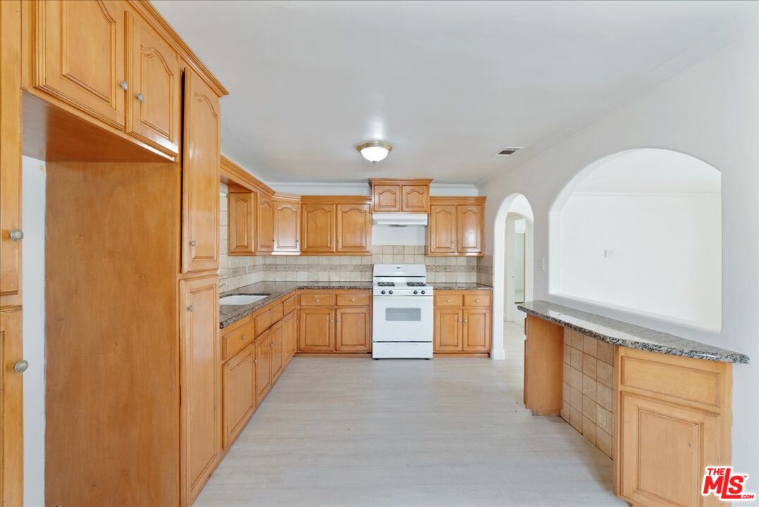 5854 Pedley Road Riverside, CA 92509 - Photo 11 of 36 a kitchen with stainless steel appliances a refrigerator and cabinets