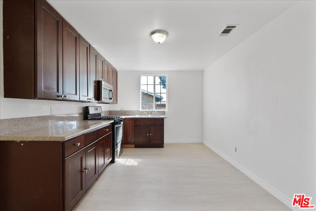 5854 Pedley Road Riverside, CA 92509 - Photo 19 of 36 a kitchen with granite countertop a sink and cabinets
