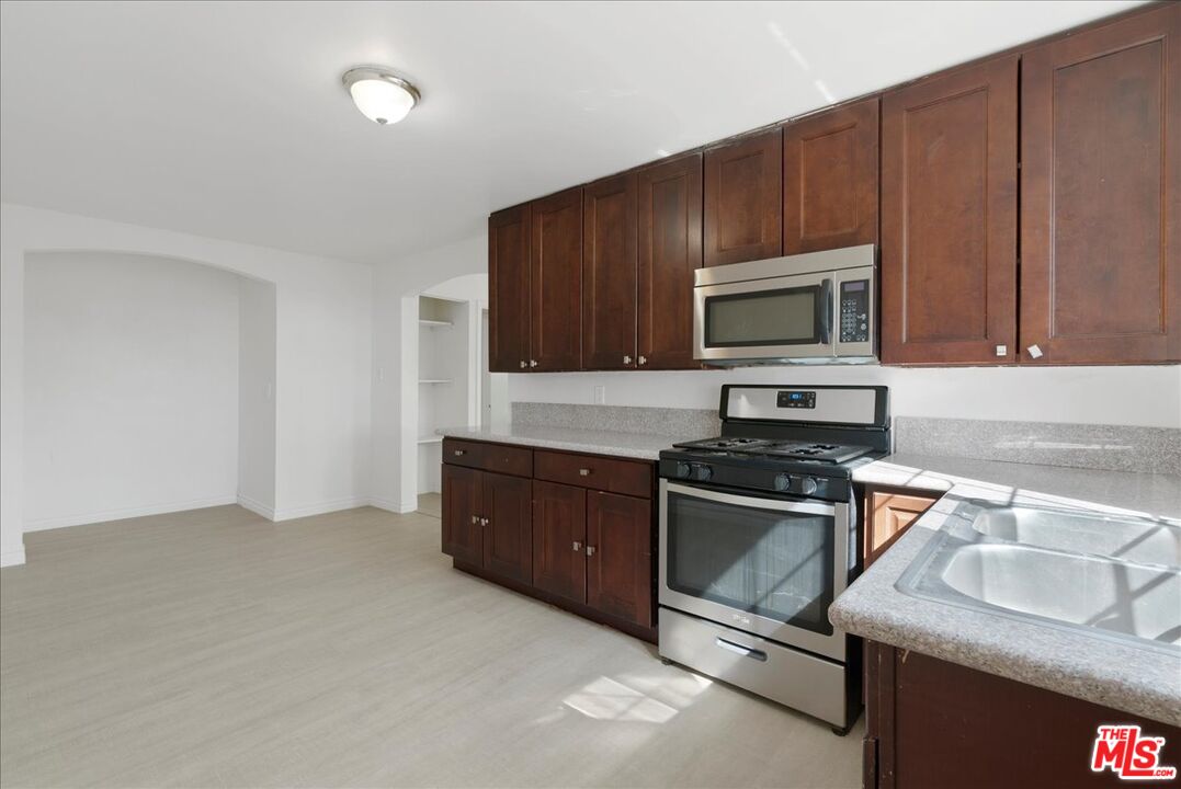5854 Pedley Road Riverside, CA 92509 - Photo 20 of 36 a kitchen with granite countertop wooden cabinets and stainless steel appliances