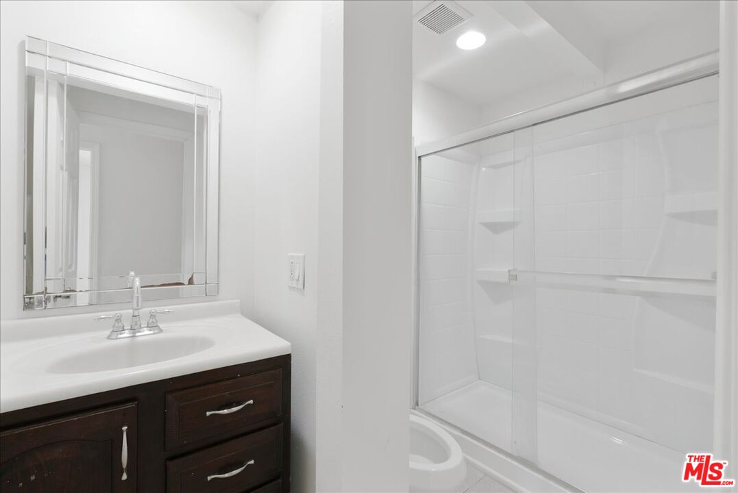 5854 Pedley Road Riverside, CA 92509 - Photo 23 of 36 a bathroom with a shower sink vanity and mirror