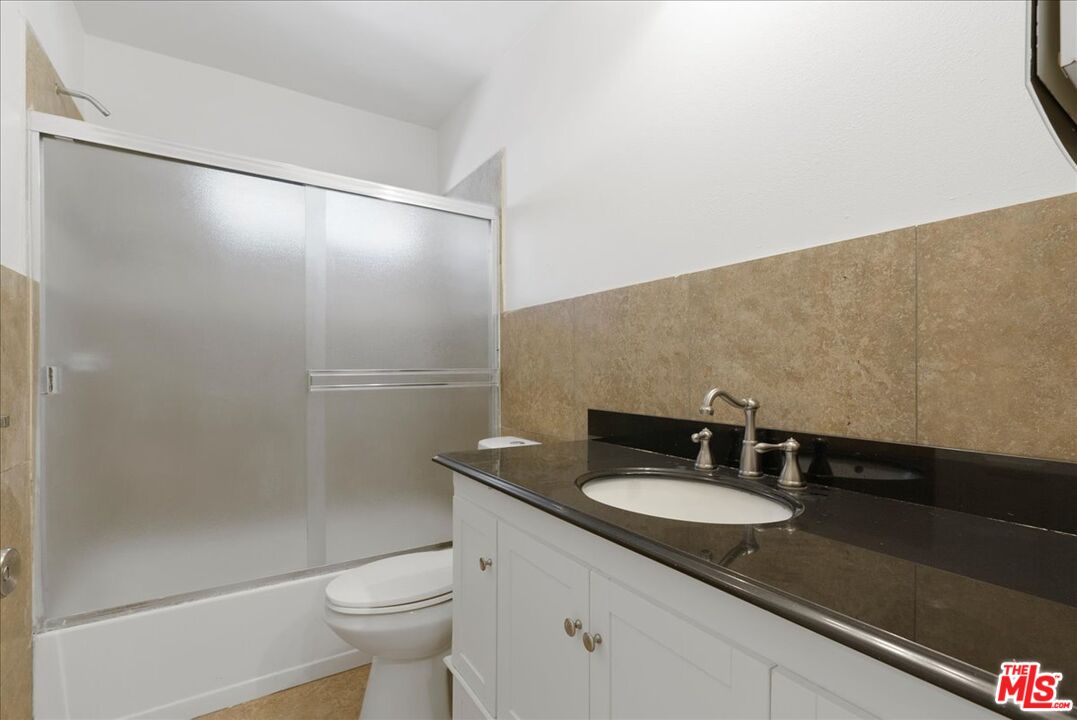 5854 Pedley Road Riverside, CA 92509 - Photo 25 of 36 a bathroom with a granite countertop sink toilet and a mirror