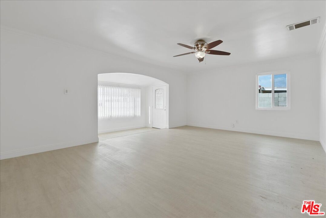 5854 Pedley Road Riverside, CA 92509 - Photo 8 of 36 an empty room with chandelier fan and windows