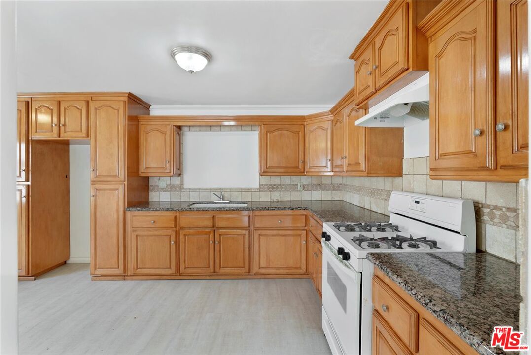 5854 Pedley Road Riverside, CA 92509 - Photo 9 of 36 a kitchen with stainless steel appliances granite countertop a stove a sink and a refrigerator with wooden floors