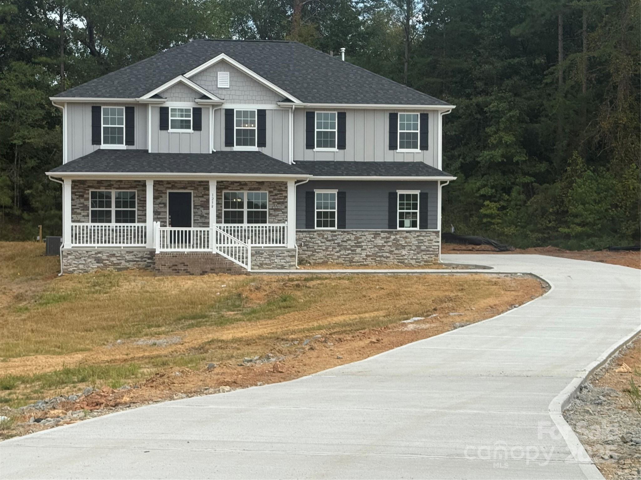 a front view of a house with a yard and trees