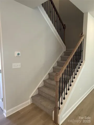 a view of staircase with wooden floor and white walls