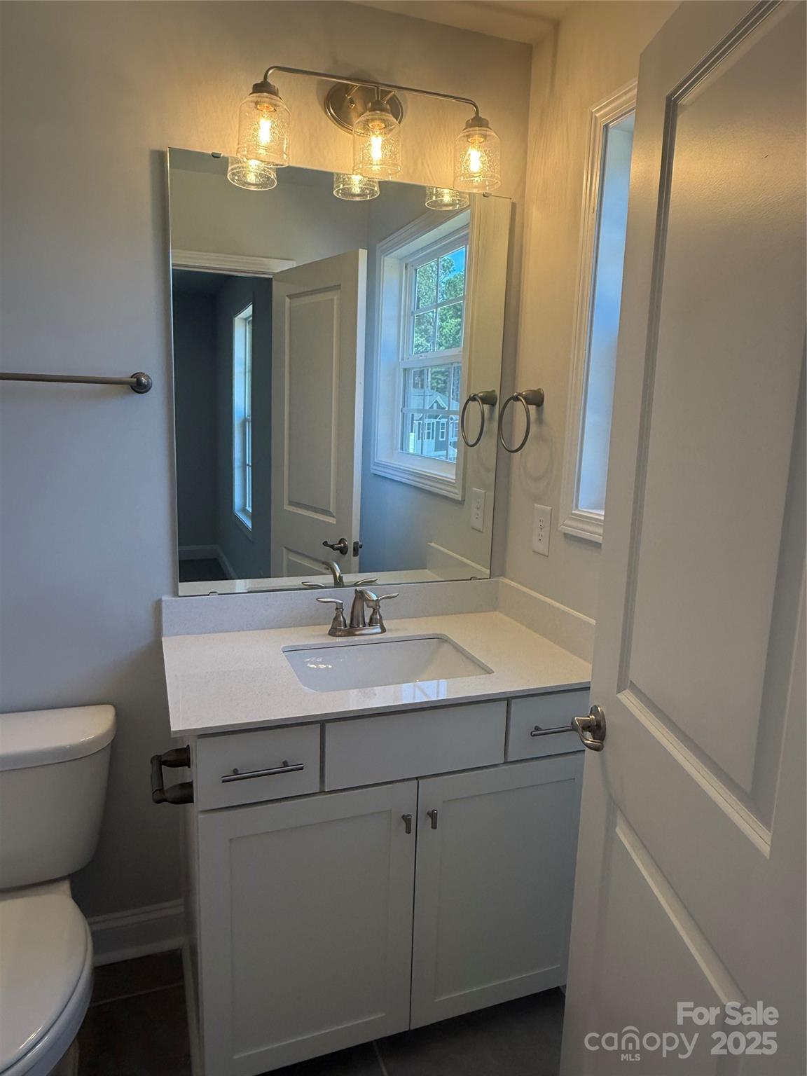 1258 Willow Grove Lane, Unit 101 Clover, SC 29710 - Photo 20 of 39 a bathroom with a granite countertop sink a toilet and a mirror