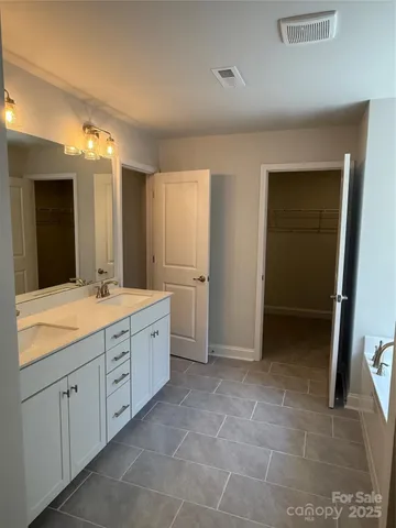 a spacious bathroom with a granite countertop sink a mirror and a vanity