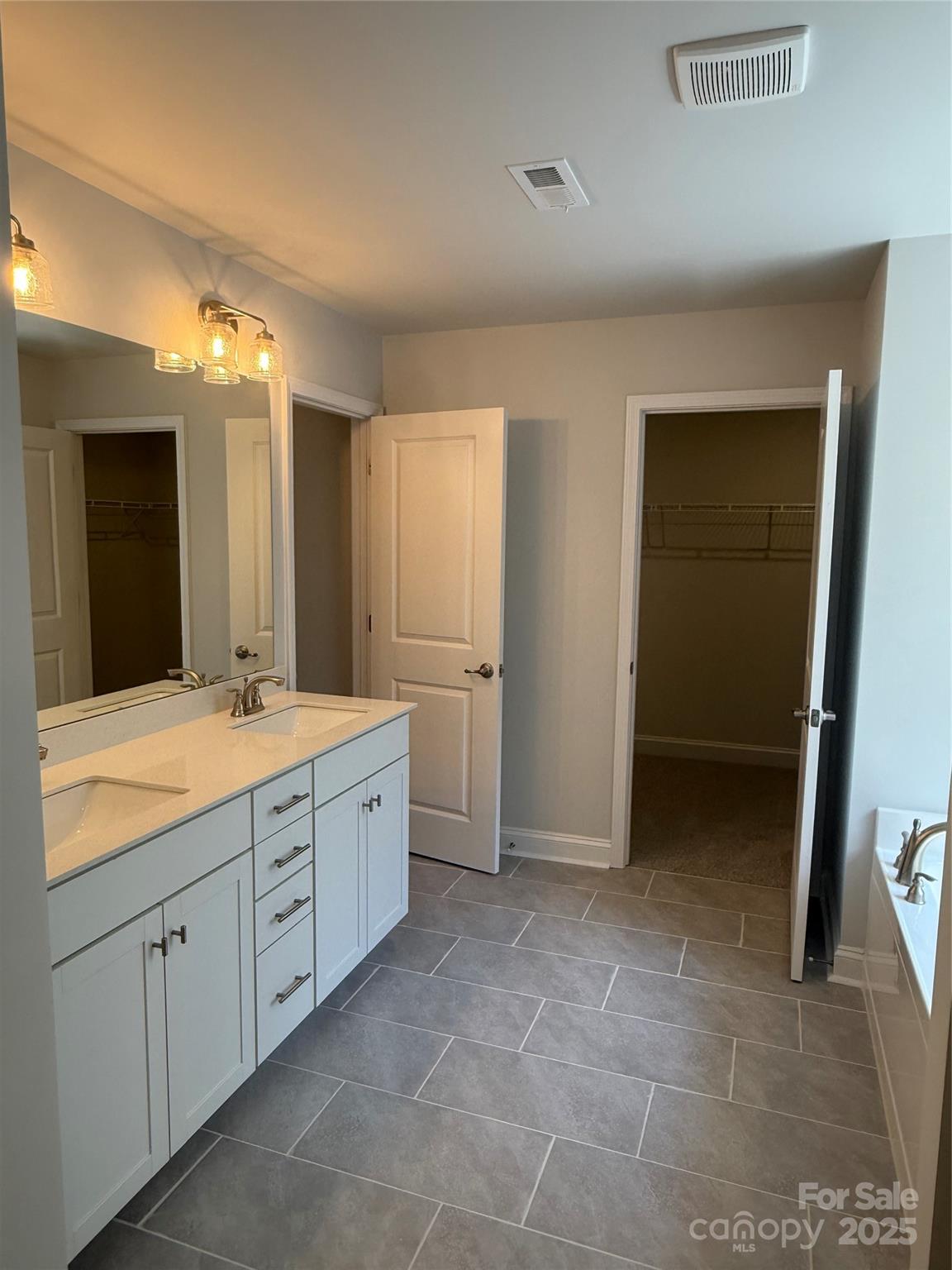 1258 Willow Grove Lane, Unit 101 Clover, SC 29710 - Photo 30 of 39 a spacious bathroom with a granite countertop sink a mirror and a vanity