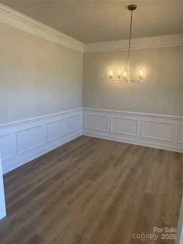 a view of a room with wooden floor and ceiling fan