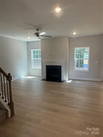 an empty room with windows and fireplace
