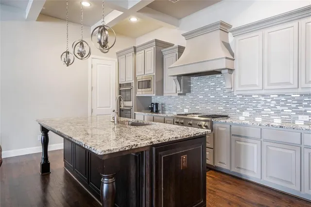 a kitchen with a sink dishwasher and cabinets with wooden floor