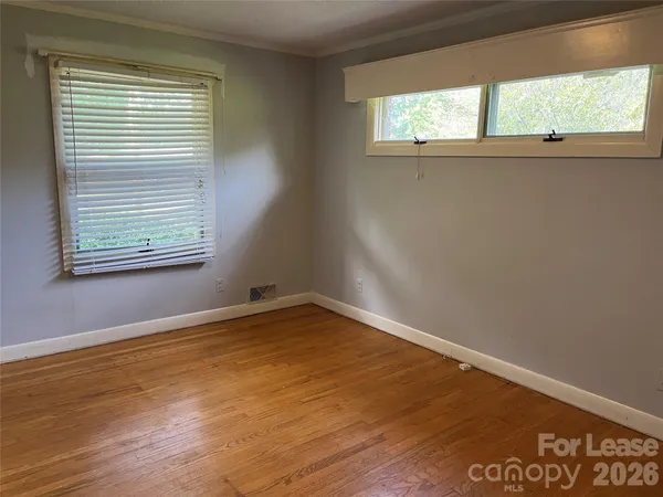 a view of a room with wooden floor and windows