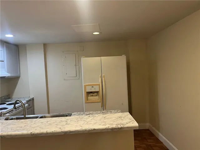 a bathroom with a granite countertop sink and a refrigerator