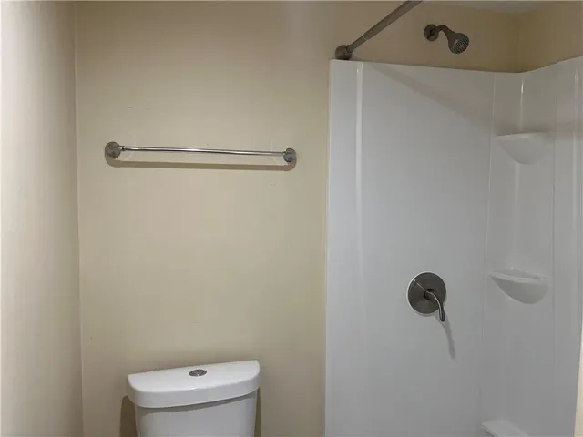 a bathroom with a toilet and a shower