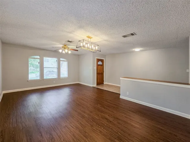 a view of a room with wooden floors and window