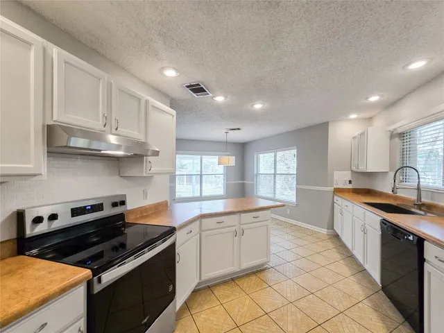 a kitchen with stainless steel appliances a stove sink and cabinets