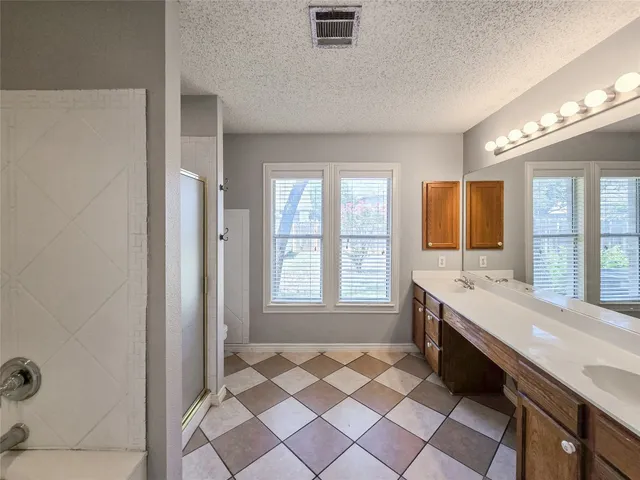a large bathroom with a double vanity sink a large mirror and a bathtub