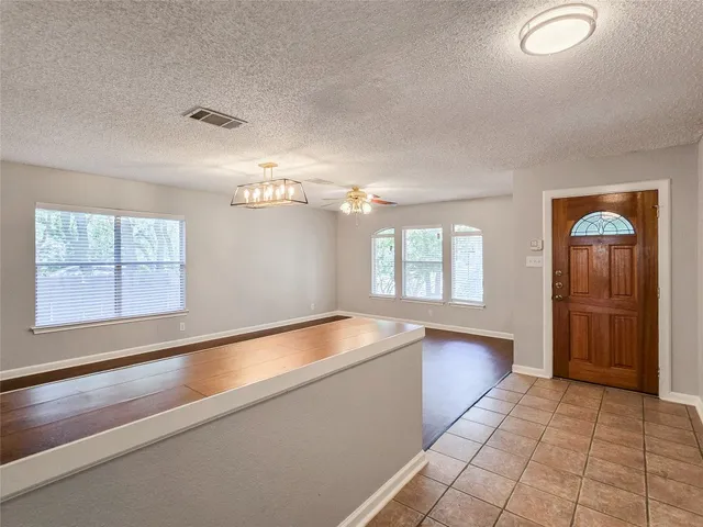 a large white kitchen with granite countertop a large window