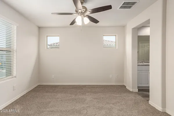 an empty room with a window and a fan