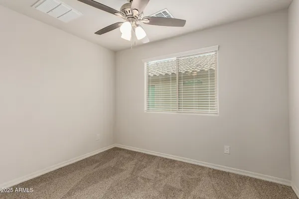 an empty room with a window and a fan